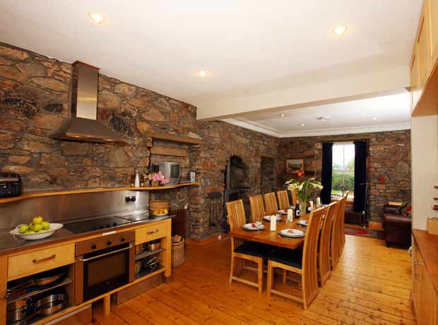 modern kitchen dinnig area with original bare stone wall