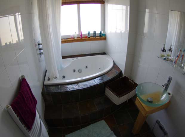corner bath and freestanding sink in bathroom